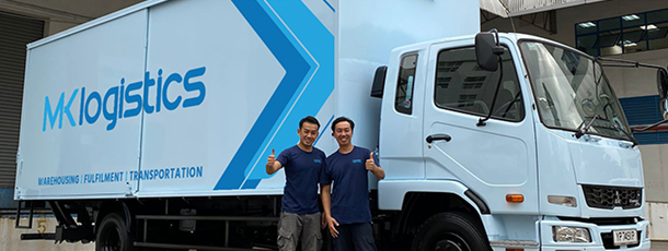 MK Logistics drivers beside a delivery truck